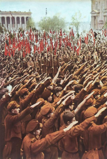 Gęste szeregi członków Hitlerjugend wznoszących prawe ramię w geście Heil Hitler.