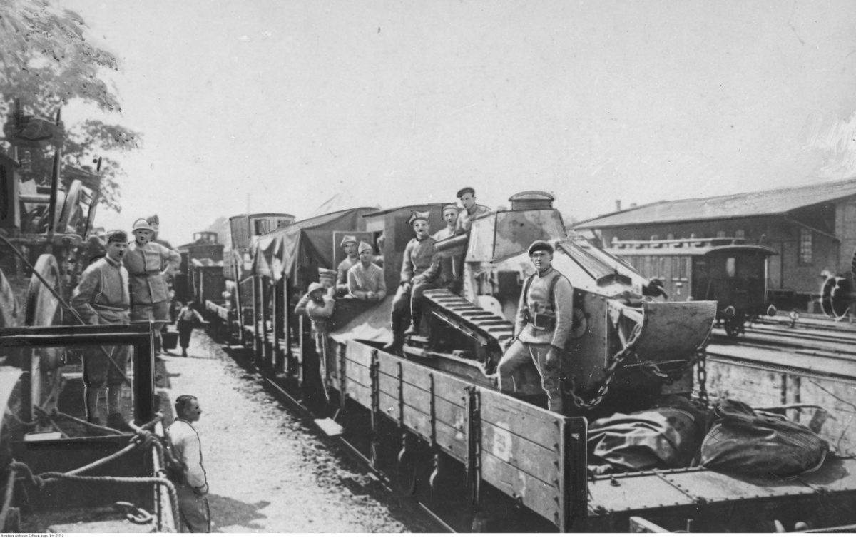 Transport oddziałów armii generała Józefa Hallera z Francji do Polski. Żołnierze na platformie kolejowej przewożącej czołg Renault FT-17 (fot. Narodowe Archiwum Cyfrowe, sygn. 3/1/0/1/297/2, domena publiczna)