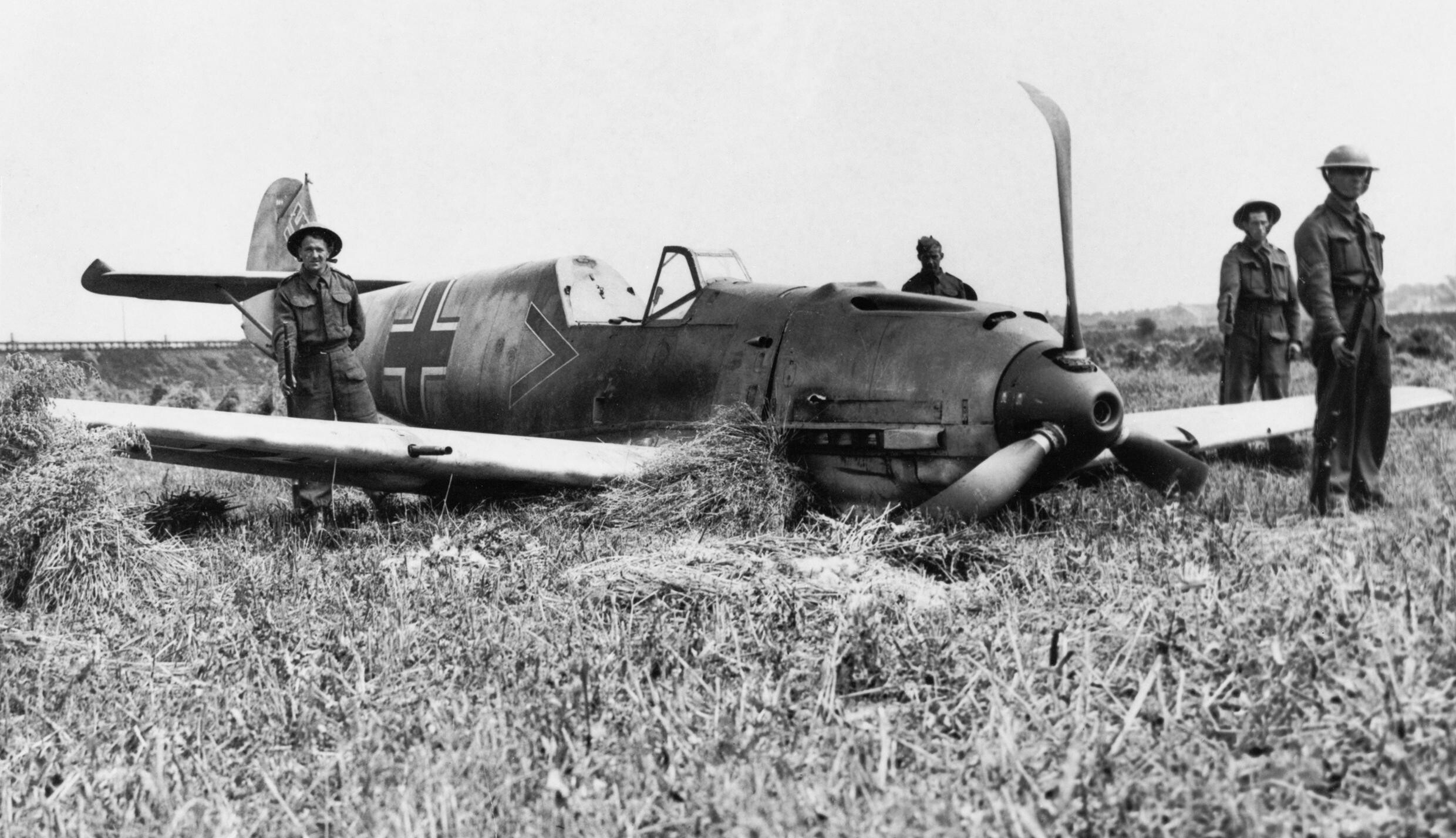Rzadko kiedy niemieckie maszyny przybywały na brytyjską ziemię w tak idealnym stanie. Widoczni na zdjęciu wartownicy, stojący przy wraku Messerschmitta Bf 109E-1 oberleutnanta Paula Temmego, mają odstraszać łowców pamiątek – największych wrogów brytyjskich techników i oficerów wywiadu; 13 sierpnia 1940 r, (fot. ze zbiorów Imperial War Museum, sygn. HU 67701, IWM Non-Commercial Licence)